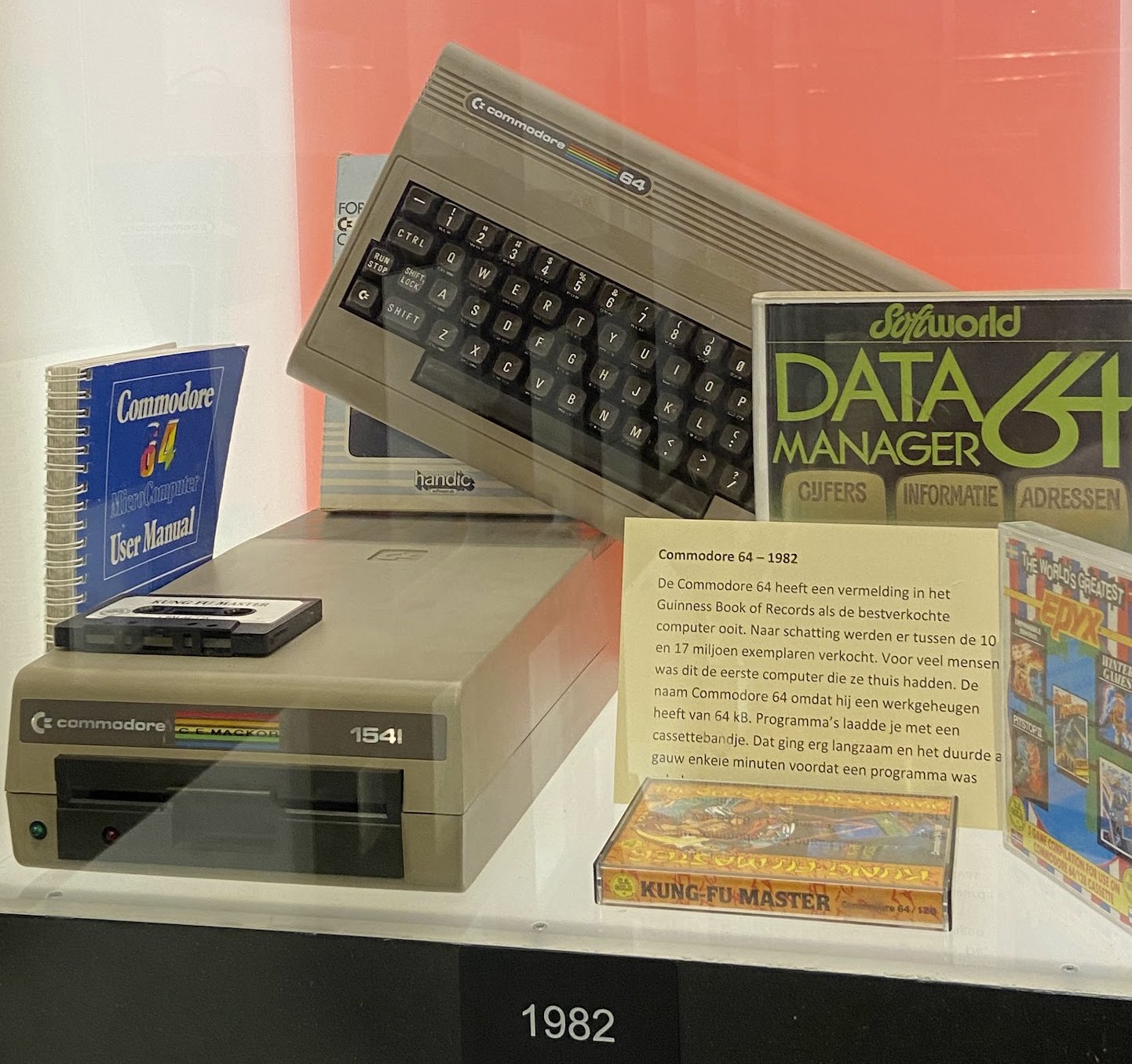 A Commodore 64 with its cassette drive, a user manual and a Data Manager 64 software box